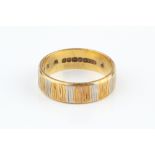 AN 18CT THREE COLOUR GOLD WEDDING BAND, of textured flat section design, ring size O