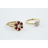 A RUBY AND DIAMOND CLUSTER RING, modelled as a stylized flowerhead, the central round brilliant-