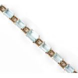 AN AQUAMARINE SET BRACELET, designed as a line of graduated rectangular step-cut aquamarines in four