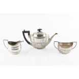 A SILVER TEAPOT, of half lobed oval form with ebonised handle and knop, and with matching twin