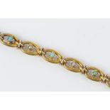 A LATE VICTORIAN/EDWARDIAN GEM SET BRACELET, of curb-link design, alternately spaced with half