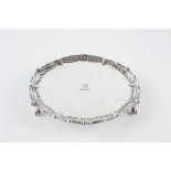 A GEORGE III SILVER SMALL SALVER, the shaped and beaded border embossed with swags, on claw and ball