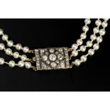 A PEARL TRIPLE STRAND NECKLACE WITH DIAMOND SET CLASP, comprising three strands of mostly uniform