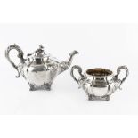 AN EARLY VICTORIAN IRISH SILVER TEAPOT, and matching twin handled sucrier, embossed and engraved