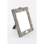 A LATE VICTORIAN SILVER RECTANGULAR EASEL MIRROR, pierce decorated and embossed with masks, putti,