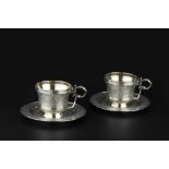 A PAIR OF 19TH CENTURY FRENCH SILVER TEA CUPS AND SAUCERS, chased and engraved with stylised