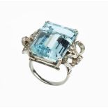 AN AQUAMARINE AND DIAMOND COCKTAIL RING, the rectangular step-cut aquamarine in double claw setting,