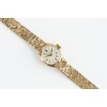 A LADY'S 9CT GOLD BRACELET WATCH BY LONGINES, the circular silvered dial with baton markers, to a