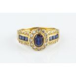 A SAPPHIRE AND DIAMOND CLUSTER RING, centred with an oval mixed-cut sapphire and round brilliant-cut