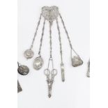 A LATE VICTORIAN SILVER CHATELAINE, pierced decorated with scrolling foliage, suspending five