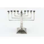 A SILVER MENORAH, with stop-fluted column, and angular branches, on beaded stepped square base, by