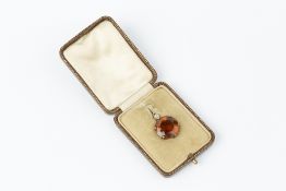 A CITRINE AND DIAMOND PENDANT, the circular mixed-cut citrine claw set below a cushion-shaped old-