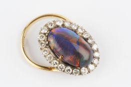 A BLACK OPAL AND DIAMOND CLUSTER RING, the oval cabochon black opal measuring approximately 16.2mm