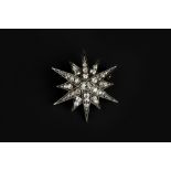 A LATE 19TH/EARLY 20TH CENTURY DIAMOND STAR BROOCH, grain set with graduated cushion-shaped, old and