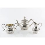 A VICTORIAN SILVER THREE PIECE TEA SERVICE, embossed and engraved with flowering foliage and 'C'