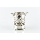 AN EDWARDIAN SILVER TWIN HANDLED BOTTLE STAND, with pierced decoration, and wooden inset base, by