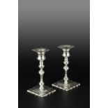 A PAIR OF GEORGE III SILVER DWARF CANDLESTICKS, with knopped and faceted stems, and embossed