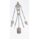 A LATE VICTORIAN SILVER CHATELAINE, of shaped outline and hung with three further panels, all