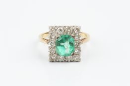 AN EMERALD AND DIAMOND CLUSTER RING, the octagonal step-cut emerald claw set within a border of