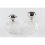 AN EDWARDIAN SILVER TOPPED GLASS SCENT BOTTLE, the shaped and hinged lid repousse decorated with