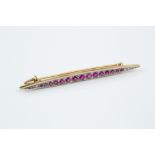 A SYNTHETIC RUBY AND DIAMOND PANEL BROOCH, the elongated navette-shaped panel millegrain set with