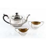 AN EDWARDIAN SILVER TEAPOT, of oval half-lobed design, with ebonised handle and knop, by James