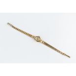 A LADY'S 9CT GOLD BRACELET WATCH BY ACCURIST, the oval silvered dial with baton markers and gilt