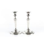 A PAIR OF EDWARDIAN SILVER CANDLESTICKS, with tapered, knopped stems on weighted circular bases,