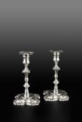 A PAIR OF GEORGE II SILVER CANDLESTICKS, with knopped stems, the shaped square bases with foliate