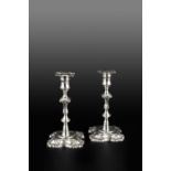 A PAIR OF GEORGE II SILVER CANDLESTICKS, with knopped stems, the shaped square bases with foliate