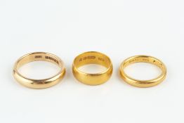 TWO 22CT GOLD WEDDING BANDS, and an 18ct gold wedding band (3)