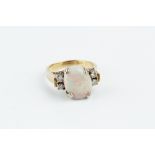 AN OPAL AND DIAMOND RING, the oval cabochon opal claw set between pairs of round brilliant-cut