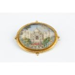 A 19TH CENTURY MINIATURE BROOCH, the oval panel painted to depict the Taj Mahal, possibly on