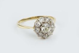 A DIAMOND CLUSTER RING, the principal old-cut diamond claw set within a border of smaller