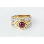 A RUBY AND DIAMOND DRESS RING, the tapered band centred with a circular cabochon ruby in lozenge-