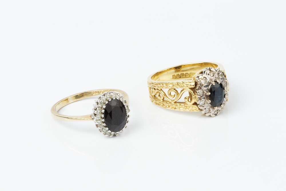 TWO SAPPHIRE AND DIAMOND CLUSTER RINGS, the first centred with an oval mixed-cut sapphire and