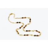 A TIGER'S EYE BEAD NECKLACE, designed as a line of reeded hoop-shaped links, spaced by pairs of