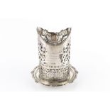 AN EDWARDIAN SILVER BOTTLE STAND, with shaped border, and pierced decoration, on dished base with