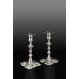 A MATCHED PAIR OF GEORGE II SILVER CANDLESTICKS, with knopped stems, and scalloped shaped square