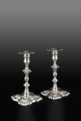 A MATCHED PAIR OF GEORGE II SILVER CANDLESTICKS, with knopped stems, and scalloped shaped square