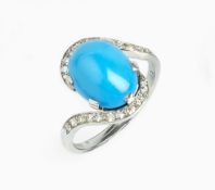 A DIAMOND SET DRESS RING, of crossover design, the oval turquoise coloured cabochon claw set between