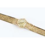 A LADY'S 9CT GOLD BRACELET WATCH BY OMEGA, the circular gilt dial with baton markers, to a calibre