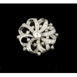 A DIAMOND PANEL BROOCH, of whorl design, centred with a round brilliant-cut diamond in eight claw