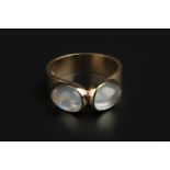 A MOONSTONE DRESS RING, centred with two pear-shaped cabochon moonstones in collet settings, 9ct