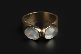 A MOONSTONE DRESS RING, centred with two pear-shaped cabochon moonstones in collet settings, 9ct