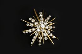 A DIAMOND STAR BROOCH, of abstract design, the tiered cluster of graduated old and single-cut