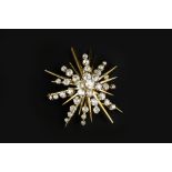 A DIAMOND STAR BROOCH, of abstract design, the tiered cluster of graduated old and single-cut