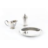 A SILVER STRAWBERRY SET, comprising cream jug and sugar castor, on lobbed feet, and oval dish, by