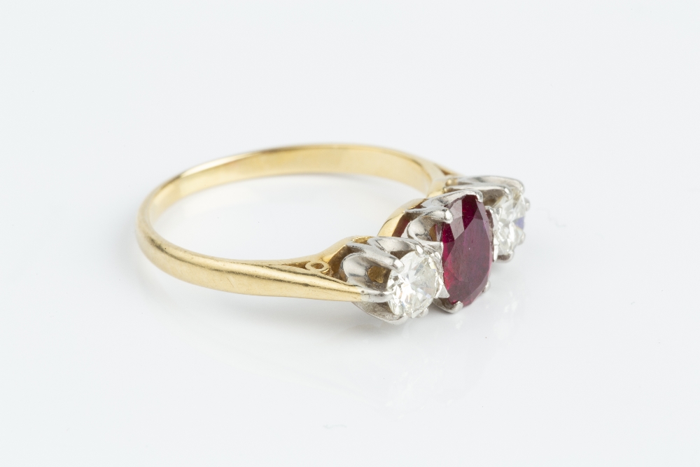 A RUBY AND DIAMOND THREE STONE RING, the oval mixed-cut ruby claw set between two round brilliant- - Image 3 of 3