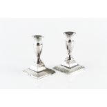 A PAIR OF GEORGE III SILVER DWARF CANDLESTICKS, with vase shaped stems, on stepped square bases,